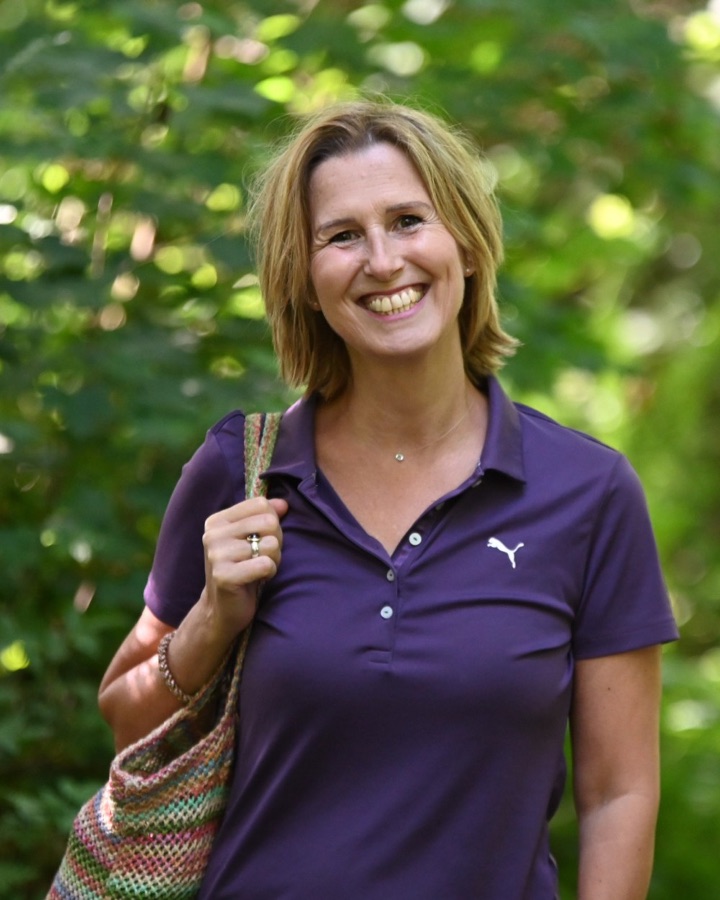 Katrin Werstler lacht offen in die Kamera, im Wald, eine bunte Tasche über der Schulter